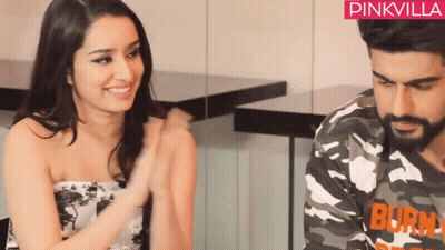 Man And Woman Sitting, Camouflage Shirt Says Burn GIF