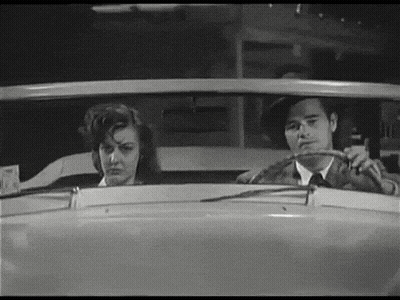 Man And Woman Sitting In Car Looking Out Window GIF