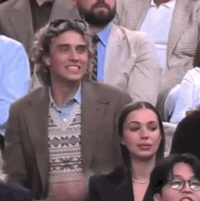 Man And Woman Sitting In Crowd GIF