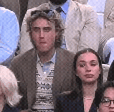 Man And Woman Sitting In Crowd GIF