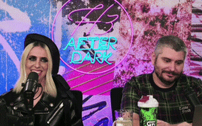Man And Woman Sitting In Front Of After Dark Neon Sign GIF