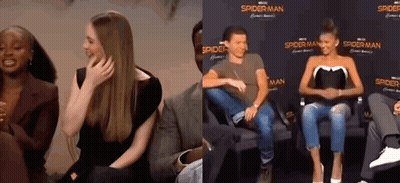 Man And Woman Sitting In Front Of Spider-Man Sign GIF