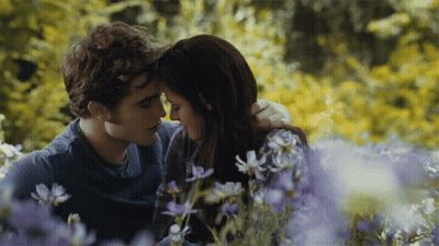 Man And Woman Sitting In Purple Flowers GIF