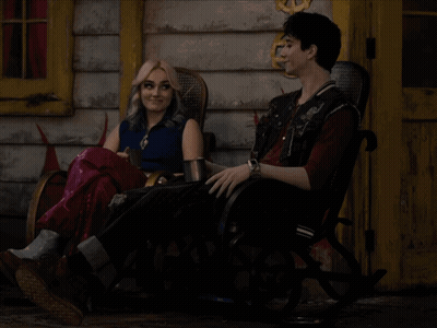 Man And Woman Sitting In Rocking Chairs Outside Building GIF