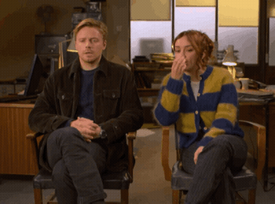 Man And Woman Sitting Next To Each Other In Chairs GIF