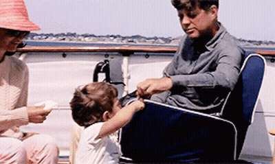 Man And Woman Sitting On Boat With Child GIF