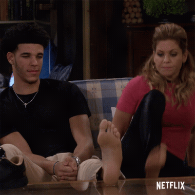 Man And Woman Sitting On Couch Feet On Table Saying Netflix GIF