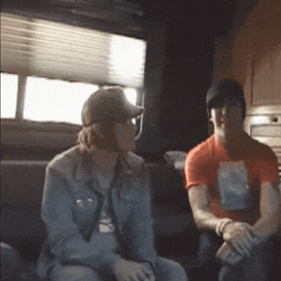 Man And Woman Sitting On Couch In Dark Room GIF