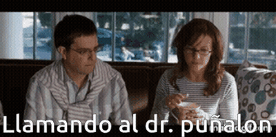 Man And Woman Sitting On Couch Llamando Al Dr. Puñalon GIF