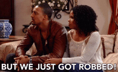 Man And Woman Sitting On Couch Saying But We Just Got Robbed GIF