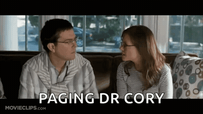 Man And Woman Sitting On Couch Saying Paging Dr Cory GIF