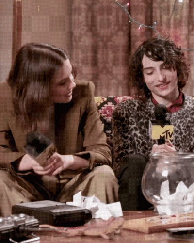Man And Woman Sitting On Couch With MTV Microphone GIF