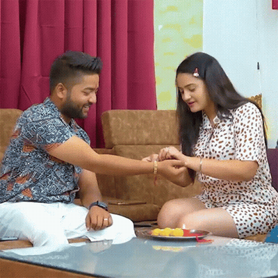 Man And Woman Sitting On Couch With Plate Of Food GIF