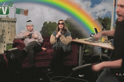 Man And Woman Sitting On Couch With Rainbow And Letter V GIF