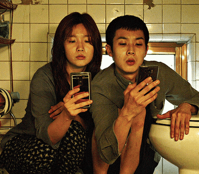 Man And Woman Sitting On Toilet Using Phones GIF