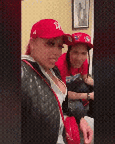 Man And Woman Sitting Together In Red Hats GIF