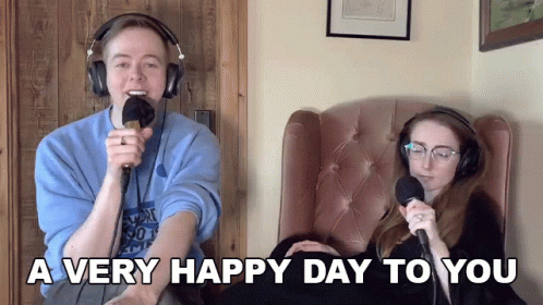 Man And Woman Sitting With Microphones Saying A Very Happy Day To You GIF
