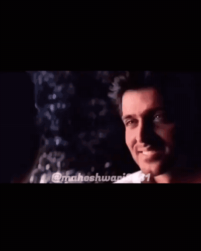 Man And Woman Smiling At Each Other In Dark Room GIF
