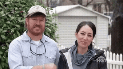 Man And Woman Smiling In Front Of Shed GIF