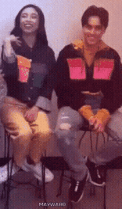 Man And Woman Smiling On Stools GIF