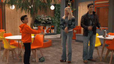 Man and Woman Standing Beside Orange Chairs