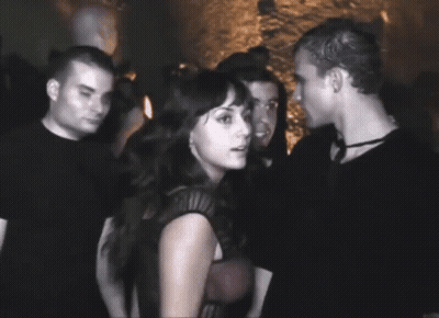 Man And Woman Standing In Crowded Room GIF