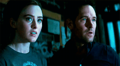 Man And Woman Standing In Dark Room Looking At Something GIF