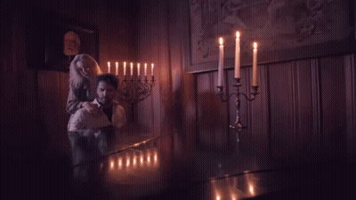 Man And Woman Standing In Dark Room With Candles GIF
