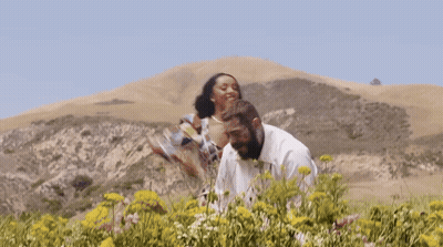 Man and Woman Standing in Field of Flowers