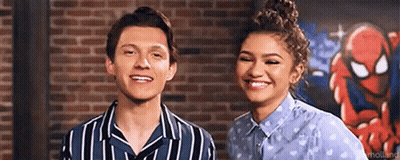 Man And Woman Standing In Front Of Brick Wall GIF