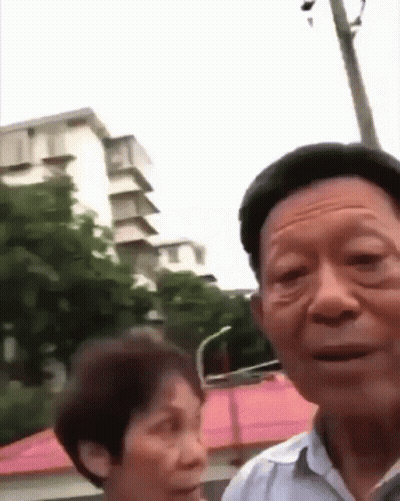Man And Woman Standing In Front Of Building GIF