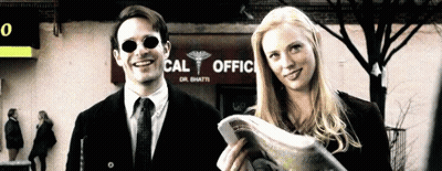 Man And Woman Standing In Front Of Cal Office GIF