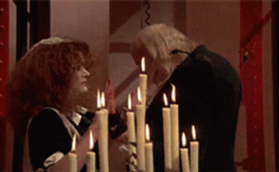 Man And Woman Standing In Front Of Candles GIF