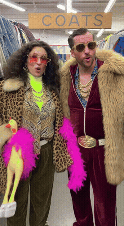 Man And Woman Standing In Front Of Coats Sign GIF