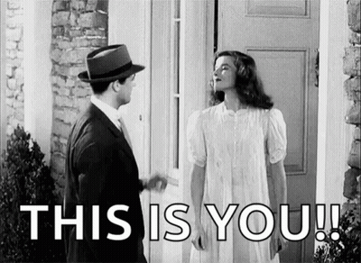 Man And Woman Standing In Front Of Door Woman In White Dress And Hat GIF
