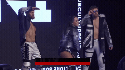Man And Woman Standing In Front Of JB Culture Sign GIF