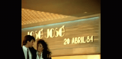 Man And Woman Standing In Front Of Jose Jose GIF