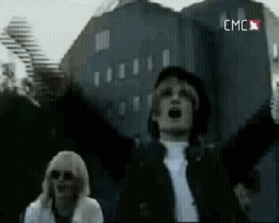 Man And Woman Standing In Front Of Large Building GIF