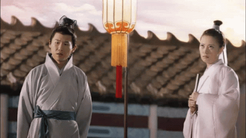 Man and Woman Standing in Front of Roof with Lantern