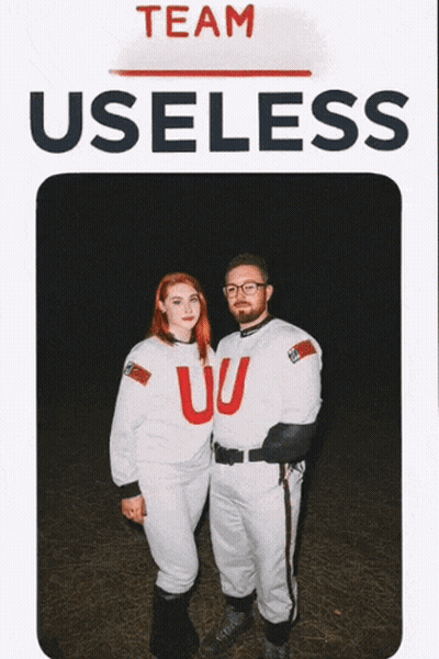 Man And Woman Standing In Front Of Team Useless Sign GIF