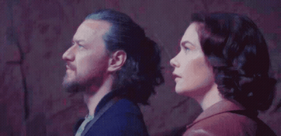 Man And Woman Standing In Front Of Wall GIF