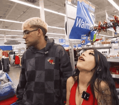 Man And Woman Standing In Front Of Walmart Sign GIF