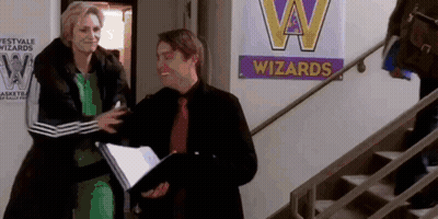 Man And Woman Standing In Front Of Wizards Sign GIF