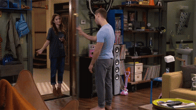 Man And Woman Standing In Living Room With Taxi Sign GIF