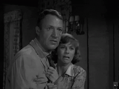 Man And Woman Standing In Room Looking At Something GIF