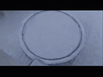 Man And Woman Standing In Snow In Front Of House GIF