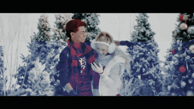 Man And Woman Standing In Snow Looking At Phone GIF