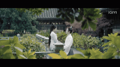 Man And Woman Standing Near Building With Iam GIF