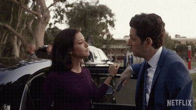 Man And Woman Standing Next To Car With Netflix Logo GIF