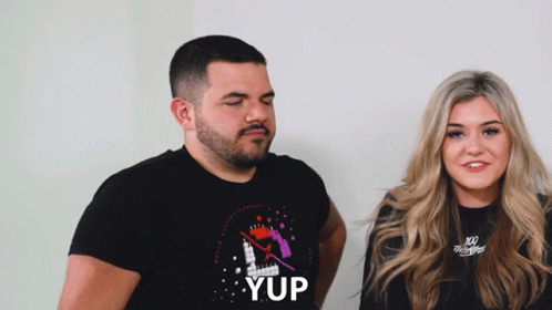 Man And Woman Standing Next To Each Other Man Wearing Yup Shirt GIF